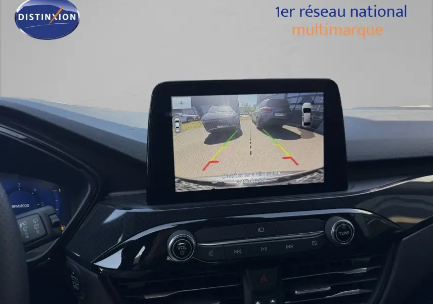 Vue du tableau de bord du Ford Kuga 2024 avec écran central affichant la caméra de recul en marche.