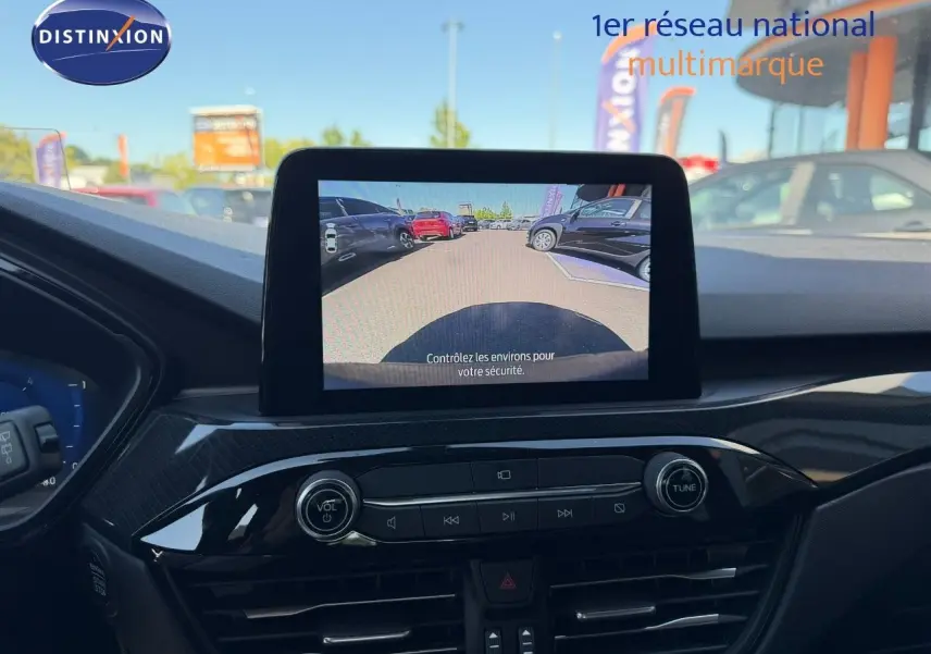 Vue intérieure du tableau de bord du Ford Kuga gris magnétique, écran central affichant la caméra de recul.
