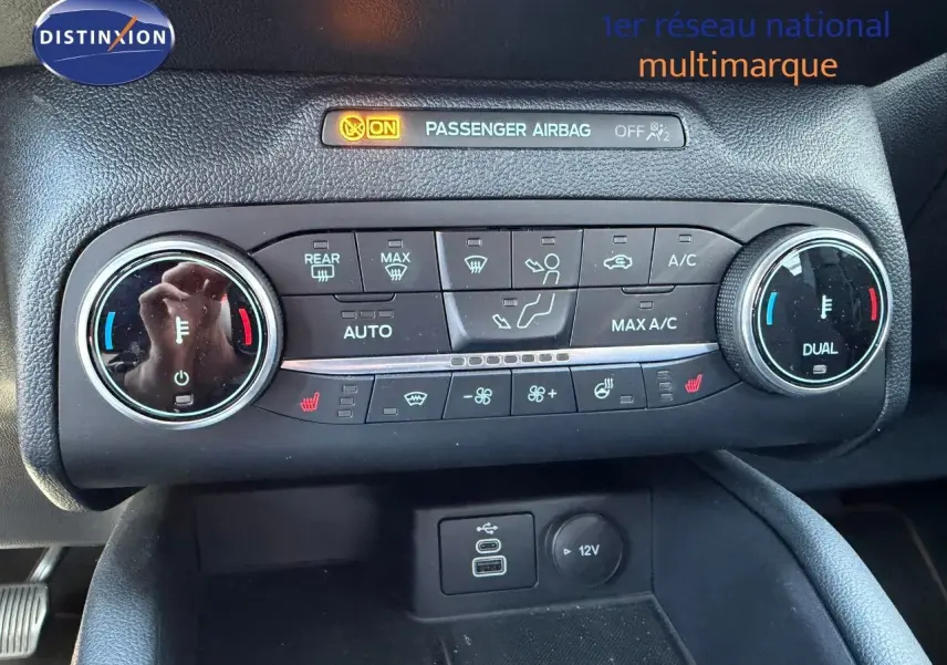 Gros plan sur la console de climatisation du Ford Kuga gris magnétique, avec commandes digitales et ports USB visibles.