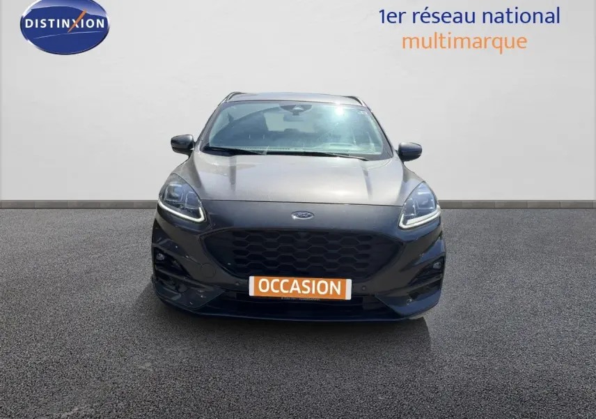 Vue frontale d'un Ford Kuga 2024 gris magnétique métal avec calandre noire et feux LED allumés.