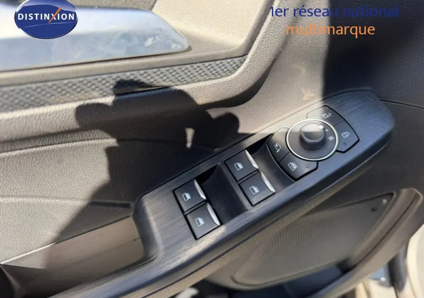 Détail des commandes de lève-vitres et rétroviseurs sur la porte côté gauche du Ford Kuga gris magnétique 2024.