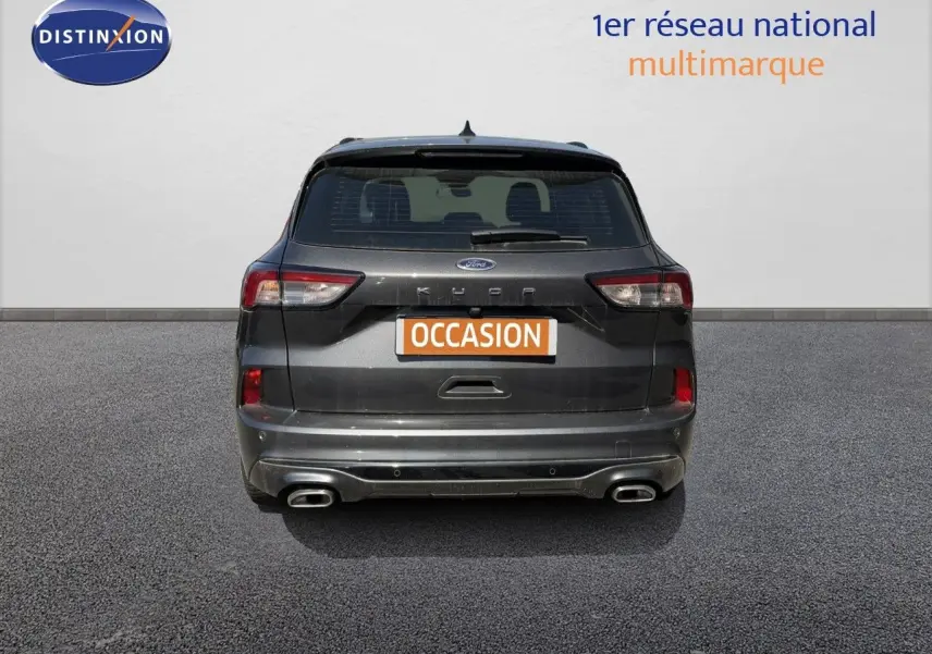 Vue arrière d'un Ford Kuga 2024 gris magnétique métallisé avec double sortie d'échappement et feux LED.