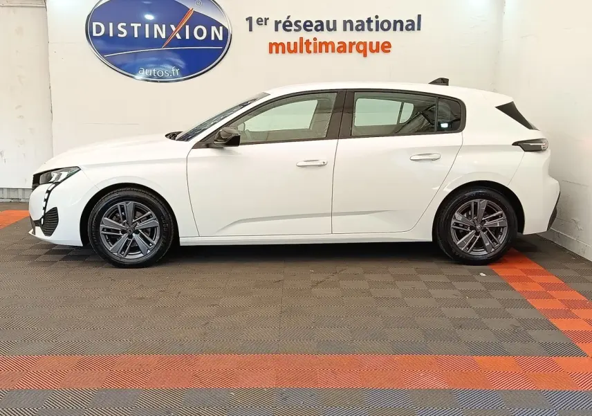 Peugeot 308 blanc vue de profil côté gauche, avec jantes alliage et feux arrière LED distinctifs.