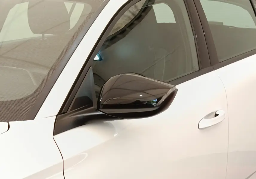 Gros plan sur le rétroviseur noir côté conducteur d'une Peugeot 308 blanche, vue latérale avant gauche.