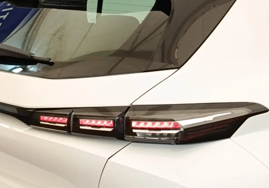 Gros plan sur les feux arrière LED rouges d'une Peugeot 308 blanche, vue côté gauche arrière.