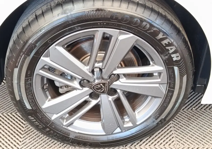 Gros plan sur la roue avant droite de la Peugeot 308 blanche, jante alliage au design moderne et pneu Goodyear.