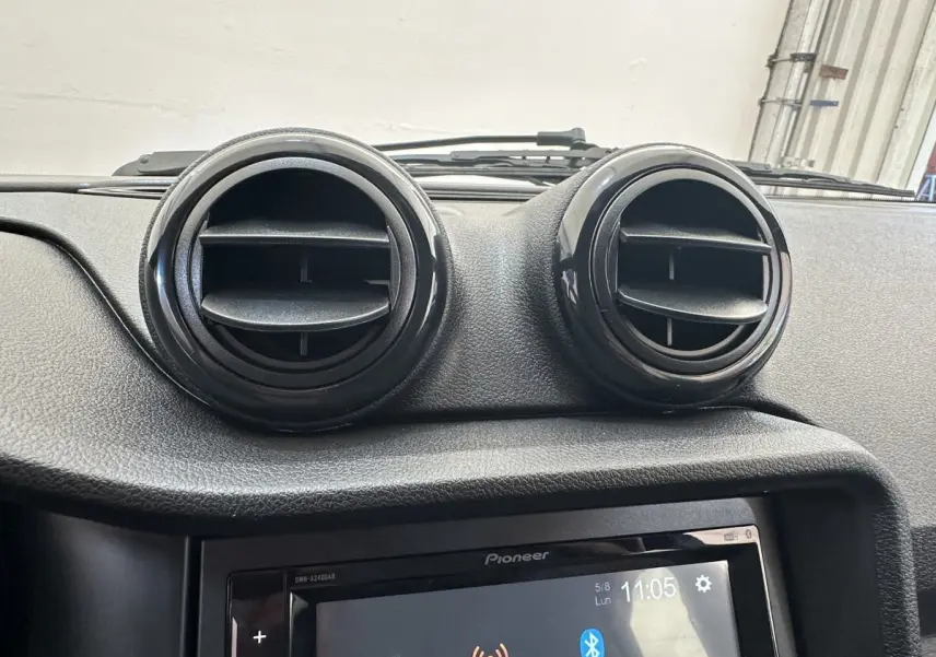 Gros plan sur la console centrale de l'AIXAM AMBITION 0.5 CITY PACK 2026, avec aérateurs ronds noirs et écran tactile Pioneer.