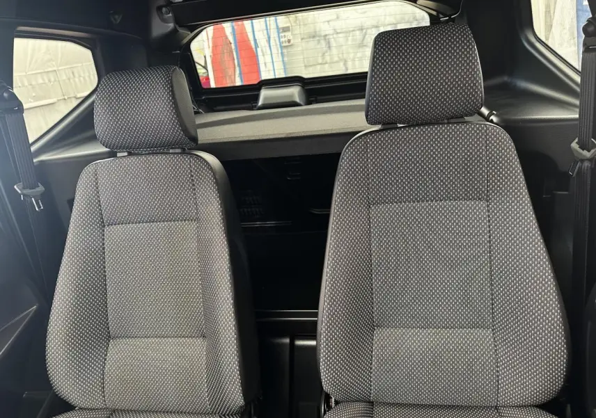 Vue intérieure frontale des sièges avant gris à motifs de l'AIXAM AMBITION 0.5 CITY PACK 2026, sans visibilité extérieure.