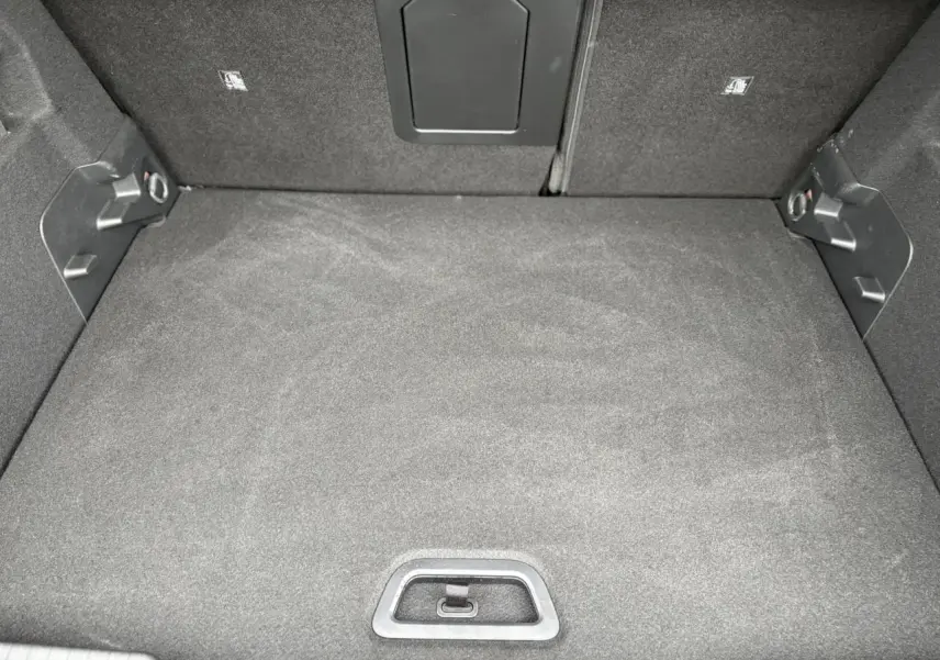 Vue plongeante sur le coffre spacieux et tapissé de tissu gris foncé du Citroën C4 Hybrid 2025.