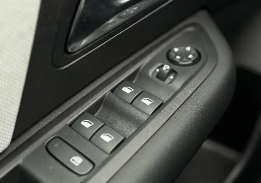 Gros plan sur les commandes de lève-vitres et rétroviseurs côté conducteur d'une Citroën C4 Hybrid 2025.