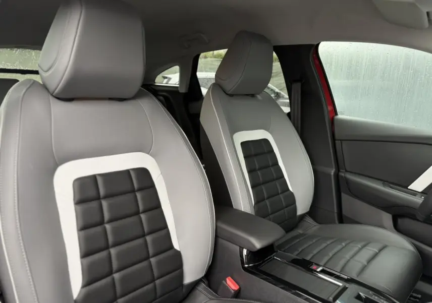 Vue intérieure rapprochée des sièges avant bi-ton gris clair et noir du Citroën C4 Rouge Elixir, côté droit visible.