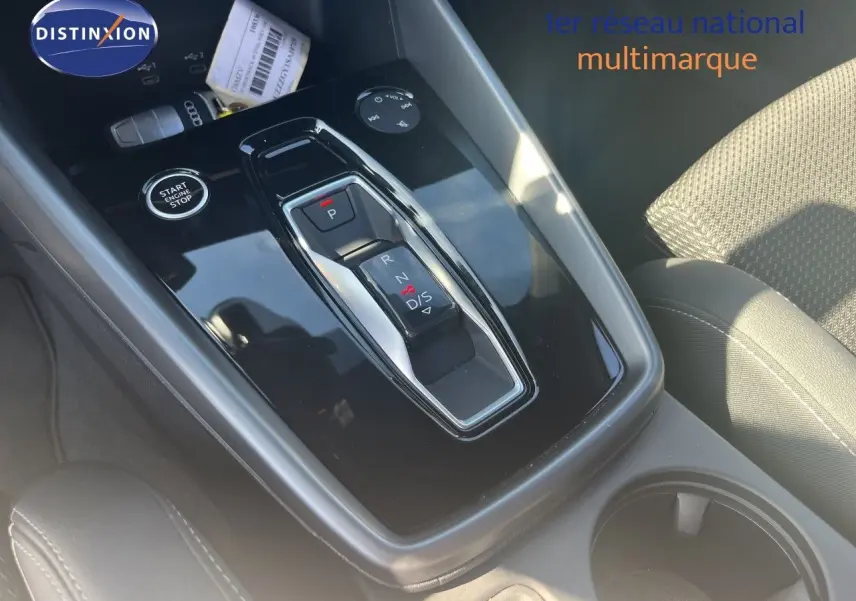 Gros plan sur la console centrale de l'Audi A3 Sportback 2025, avec levier de vitesses automatique et bouton start/stop.
