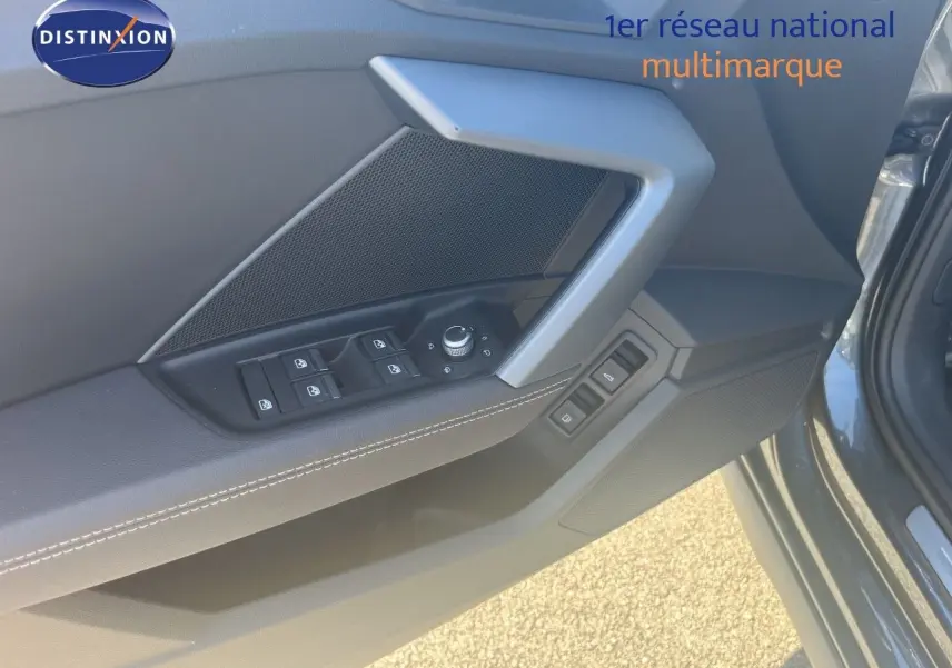 Vue rapprochée de la porte avant gauche de l'Audi A3 Sportback gris Daytona, avec commandes de vitres et rétroviseurs.