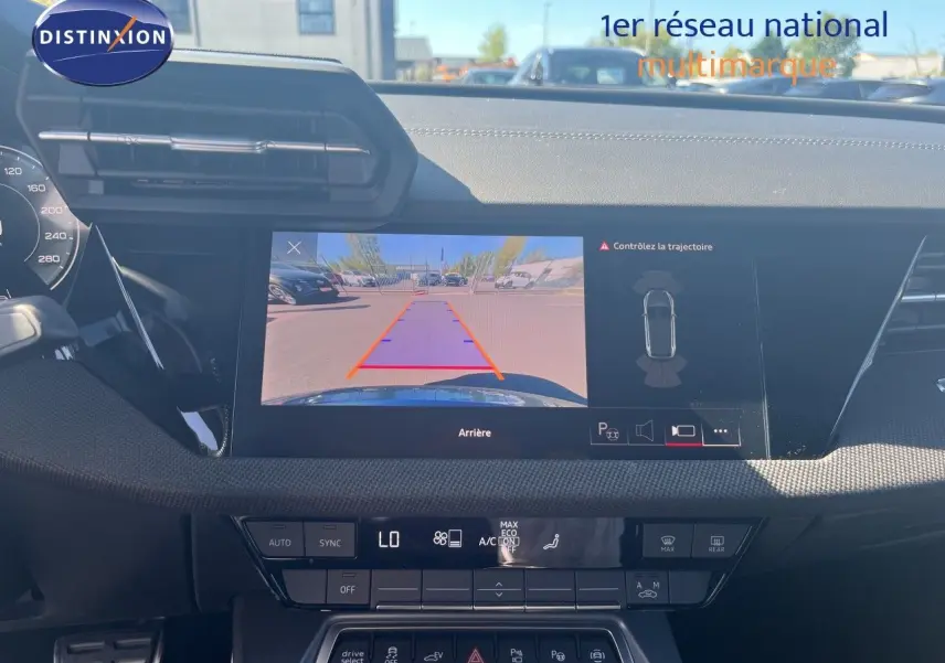 Vue intérieure du tableau de bord de l'Audi A3 Sportback 2025 avec écran de caméra de recul et commandes climatisation.