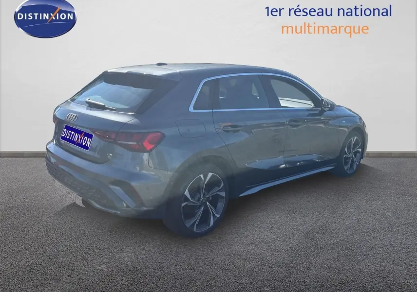 Audi A3 Sportback gris Daytona métal vue 3/4 arrière droit, avec jantes alliage et toit vitré.