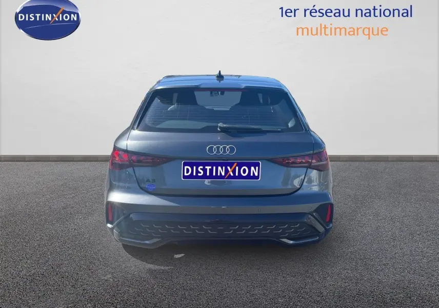 Vue arrière d'une Audi A3 Sportback gris Daytona Metal 2025 avec feux LED et hayon fermé sur sol goudronné.