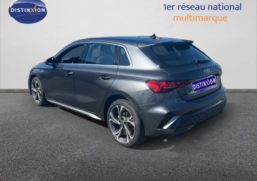 Audi A3 Sportback gris Daytona métal vue 3/4 arrière droit, avec jantes alliage et finition S-Line visible.