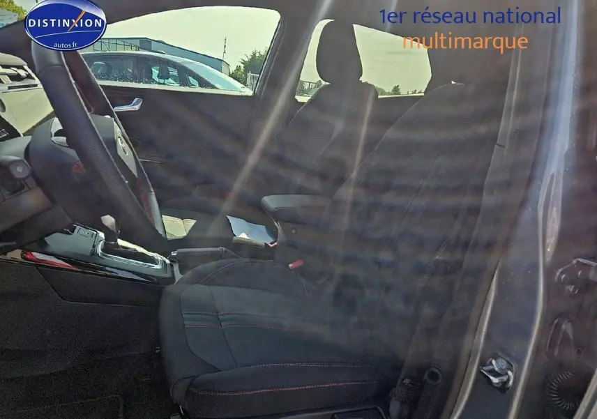 Vue intérieure côté conducteur du Ford Puma gris cactus 2025 avec sièges tissu et surpiqûres rouges visibles.