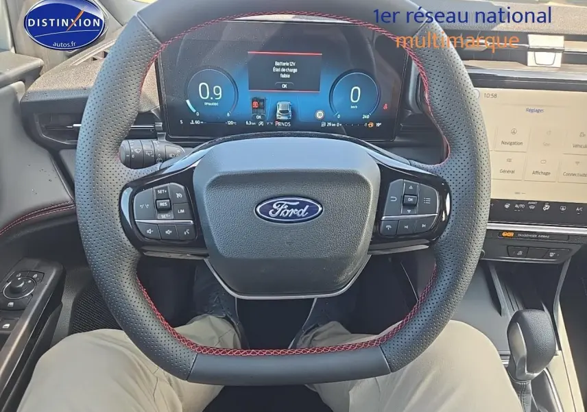 Vue intérieure centrée sur le volant perforé avec surpiqûres rouges et tableau de bord numérique du Ford Puma 2025.