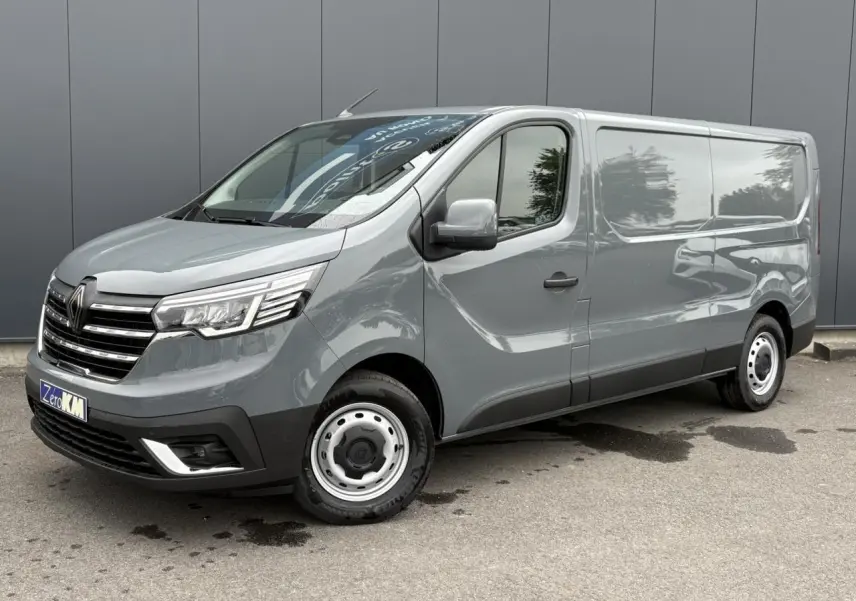 Renault Trafic Fourgon gris urbain en 3/4 avant droit, avec projecteurs Full LED et jantes acier simples.