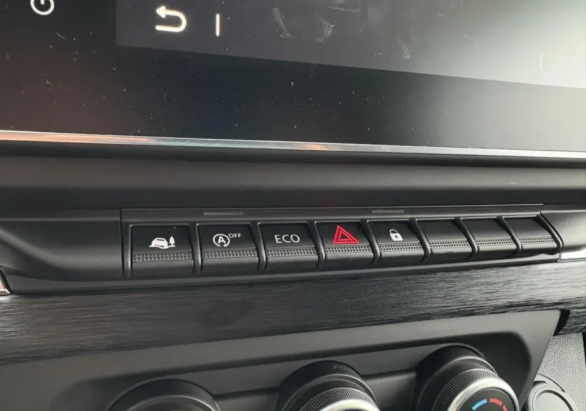 Gros plan sur la rangée de boutons de commande et les réglages de climatisation dans l'habitacle du Renault Trafic Fourgon 2025.