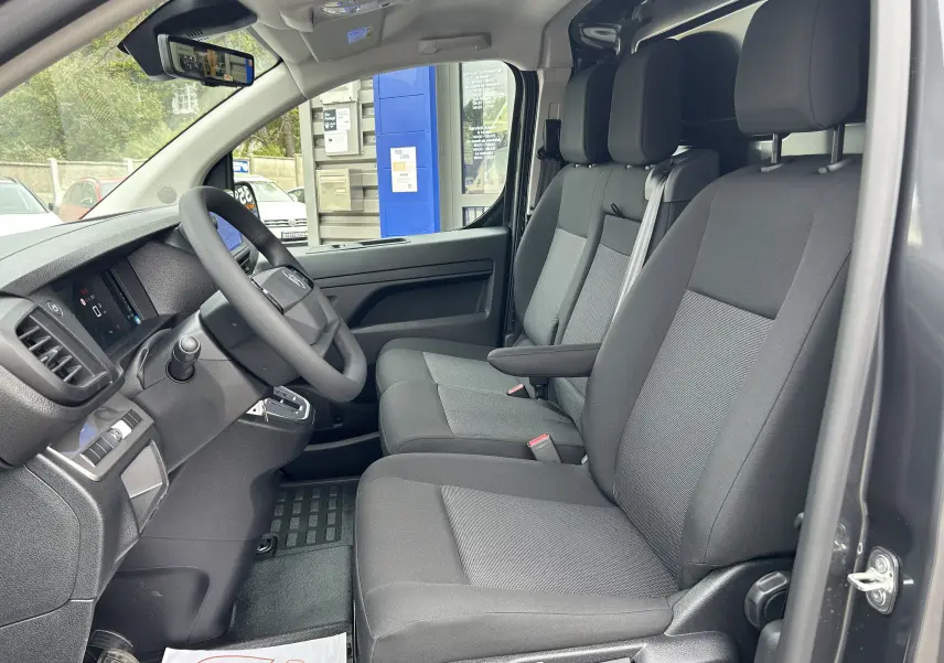 Vue intérieure côté conducteur du Citroën Jumpy gris titane 2025, montrant les sièges tissu et le tableau de bord moderne.