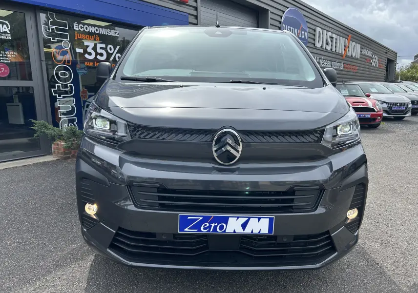 Vue frontale d'un Citroën Jumpy gris titane avec phares allumés et logo distinctif au centre de la calandre.