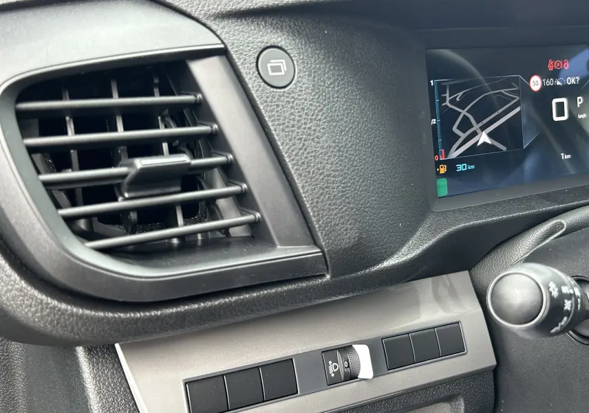 Détail du tableau de bord côté gauche du Citroën Jumpy gris titane 2025 avec écran numérique et commandes d'éclairage.