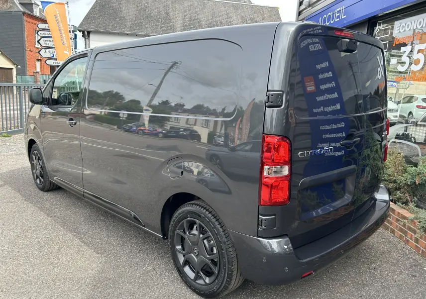 Vue 3/4 arrière droite du Citroën Jumpy gris titane 2025, fourgon utilitaire avec feux arrière rouges et jantes noires.