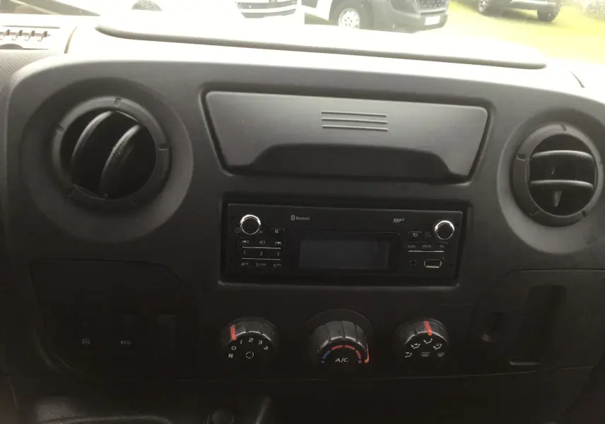 Tableau de bord noir du Renault Master Combi III 2017 avec commandes de climatisation et radio intégrée, vue frontale intérieure.
