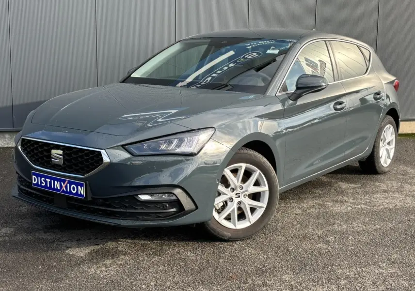 SEAT Leon 2.0 TDI 115 Style bleu Fjord en 3/4 avant droit avec jantes alliage blanches et calandre chromée.