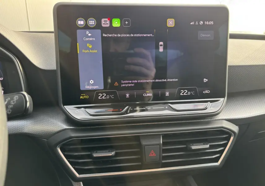 Écran tactile central du tableau de bord du SEAT Leon 2025 affichant l'assistance au stationnement et la climatisation à 22°C.