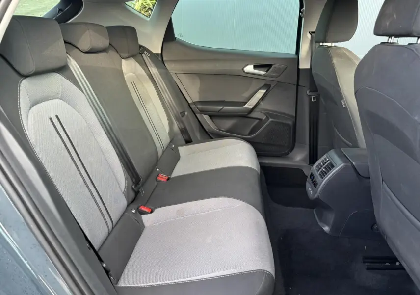Vue latérale droite de l'habitacle arrière du SEAT LEON 2.0 TDI 115 Style avec sièges bicolores gris et noir.