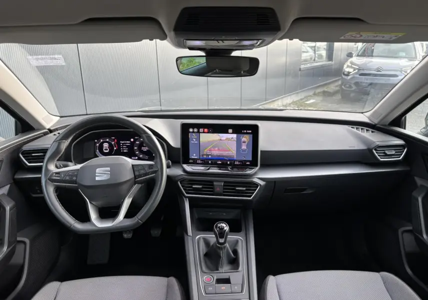 Vue intérieure frontale du poste de conduite du SEAT Leon 2.0 TDI 115 Style 2025 avec écran tactile et boîte manuelle.
