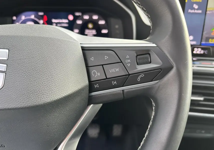 Gros plan sur le volant cuir multifonction côté droit du SEAT Leon 2.0 TDI 115 Style avec commandes intégrées.