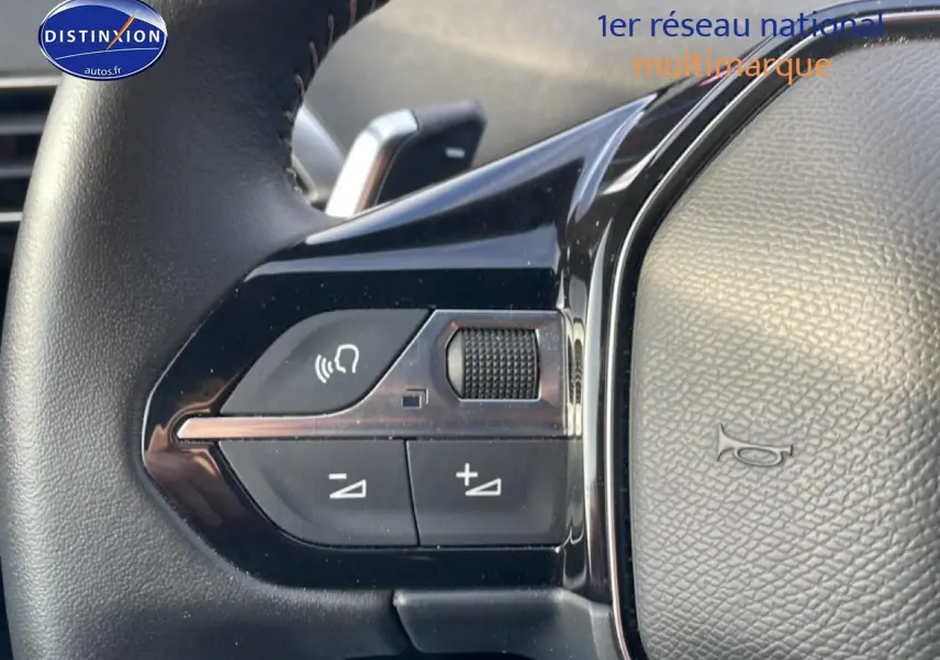 Gros plan sur les commandes vocales et volume au volant cuir du Peugeot 3008 bleu plug-in hybrid 2024.