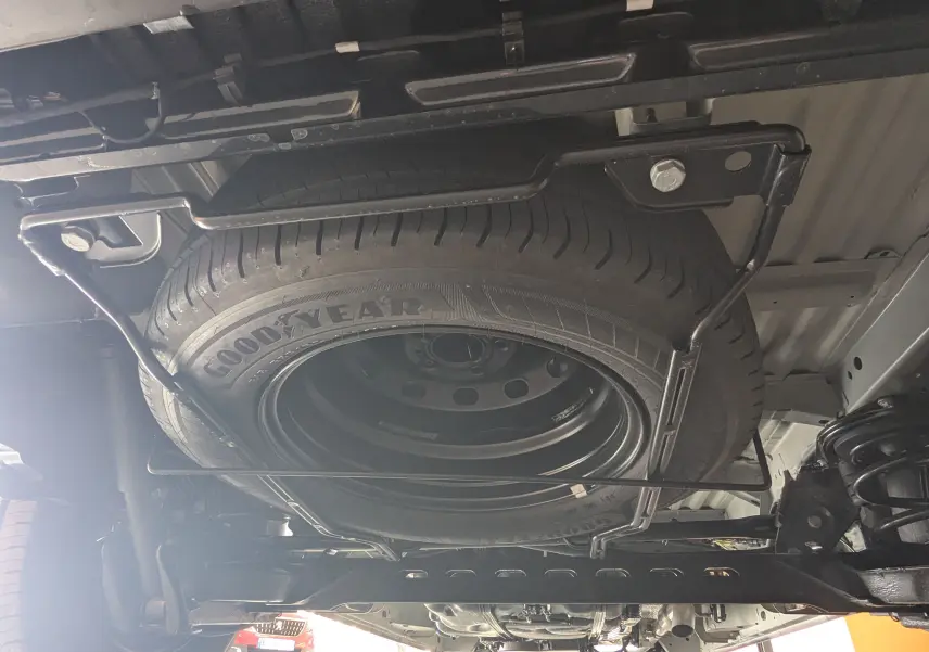 Vue sous le Renault Trafic Cabine Approfondie gris Comète 2025, montrant la roue de secours Goodyear fixée sous le châssis.