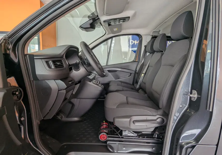 Vue intérieure côté conducteur du Renault Trafic Cabine Approfondie gris comète, montrant les sièges avant et le tableau de bord.