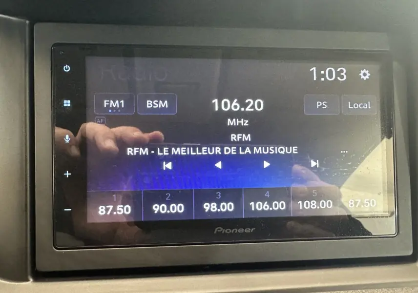Écran tactile radio Pioneer affichant la fréquence 106.20 MHz avec interface en mode FM1, dans un véhicule.