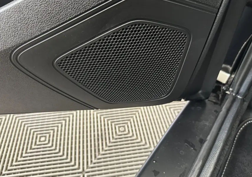 Gros plan sur l'enceinte intégrée à la porte intérieure côté conducteur d'un Aixam Ambition blanc 2026.