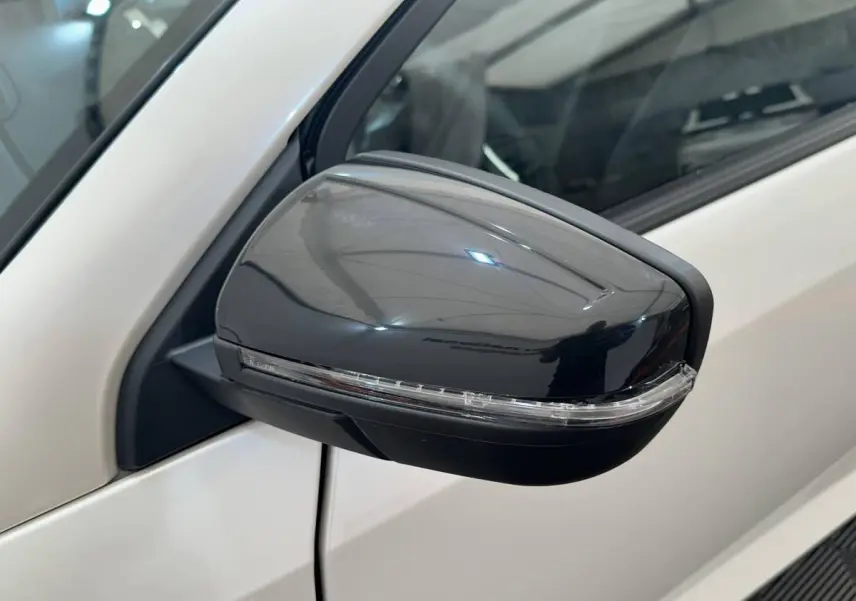 Gros plan sur le rétroviseur caméra côté conducteur noir brillant d'une Aixam Ambition 0.5 Crossover Premium blanche.