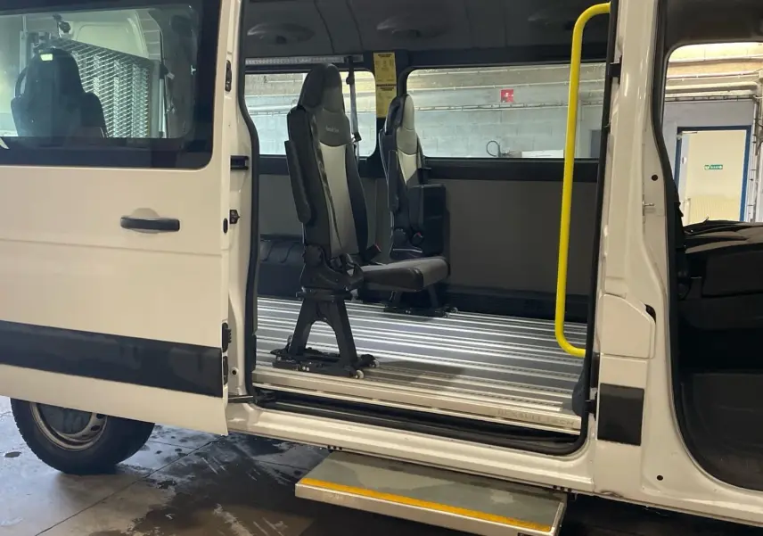 Vue latérale gauche du Renault Master blanc 2020 avec porte latérale ouverte, marchepied déployé et sièges modulables à l'intérieur.