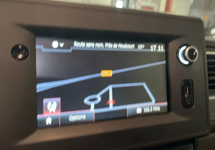 Écran de navigation GPS intégré dans le tableau de bord du Renault Master blanc, vue intérieure centrée.