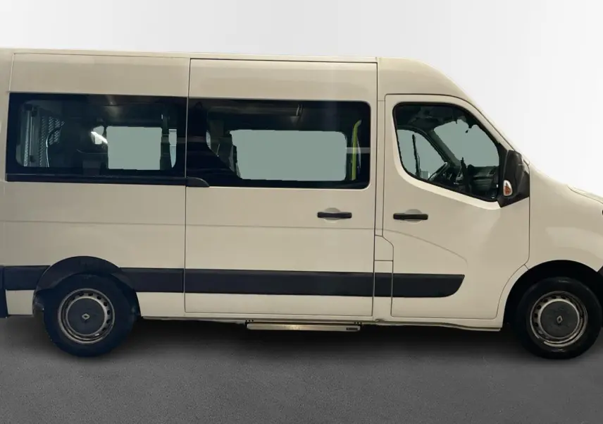 Vue latérale droite d’un Renault Master blanc 2020 avec grandes fenêtres et marchepied sous la porte coulissante.