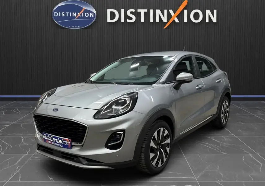 Ford Puma gris solar en vue 3/4 avant droit, avec calandre noire et jantes alliage distinctives.