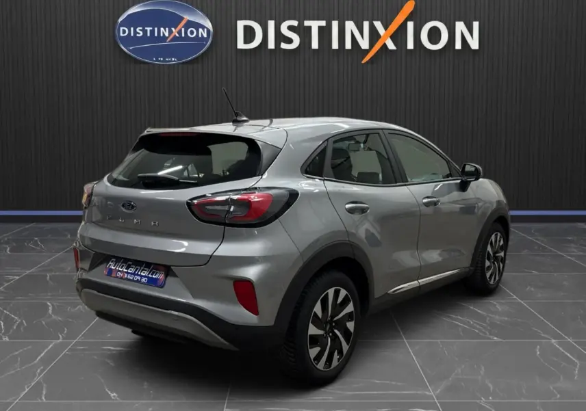 Vue 3/4 arrière droite d'un Ford Puma gris solar 2023 avec jantes alliage et feux LED distinctifs.