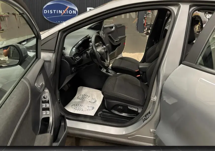 Vue intérieure côté conducteur du Ford Puma gris Solar 2023, montrant sièges noirs et tableau de bord moderne.