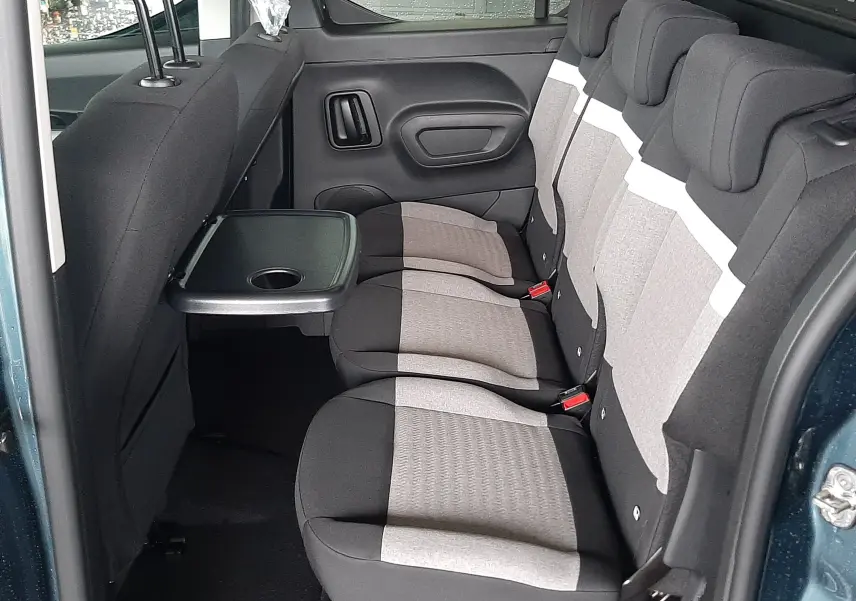 Vue intérieure côté droit du Citroën Berlingo bleu Kiama 2026, montrant la banquette arrière avec tablette rabattable.