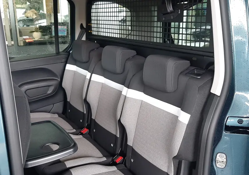 Vue intérieure côté droit du Citroën Berlingo bleu Kiama, montrant la banquette arrière grise avec tablette rabattable.