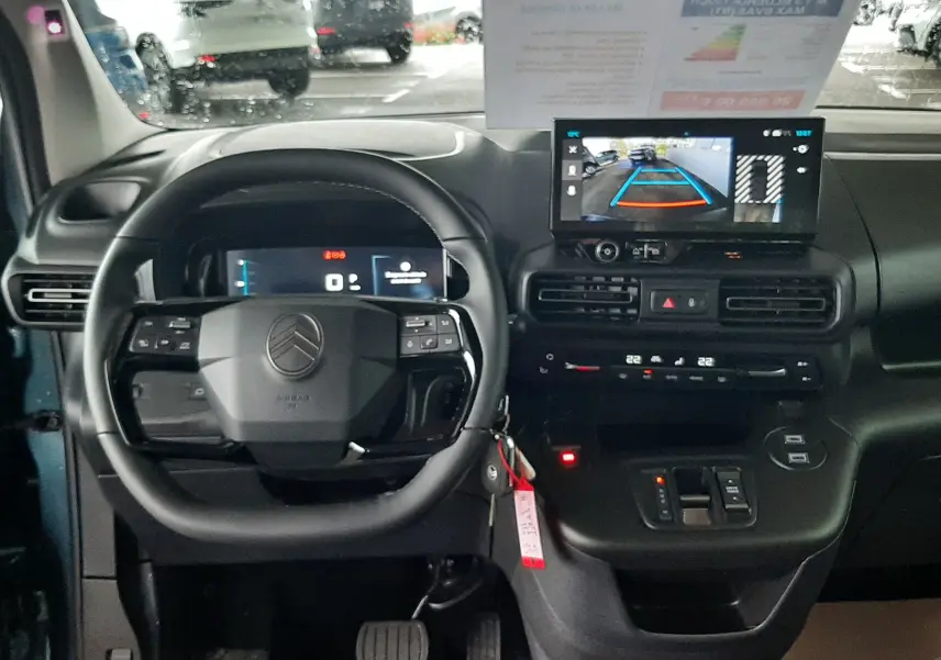 Vue intérieure avant du Citroën Berlingo bleu Kiama 2026, tableau de bord avec écran de caméra de recul et volant multifonction.